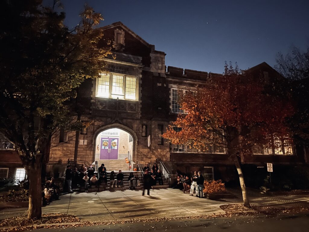 Tour group listening to a guide during a Church Hill Chillers tour at Bellevue Elementary School in Richmond, Virginia.