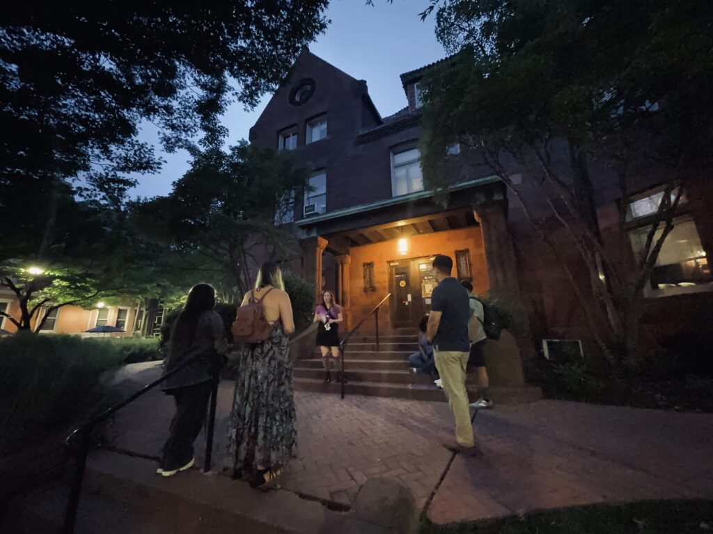 Tour group listening to a guide during a Creepy Tales on Campus tour at Ginter House in Richmond, Virginia.