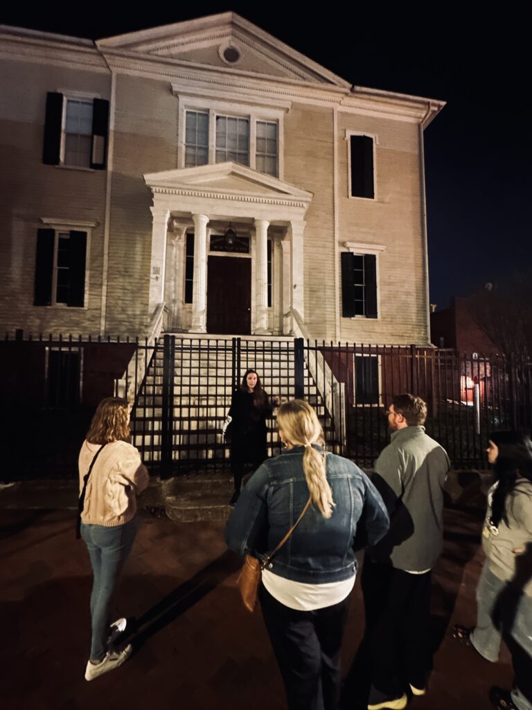 Tour group listening to a guide during a Shadows of Shockoe tour at Masons' Hall in Richmond, Virginia.