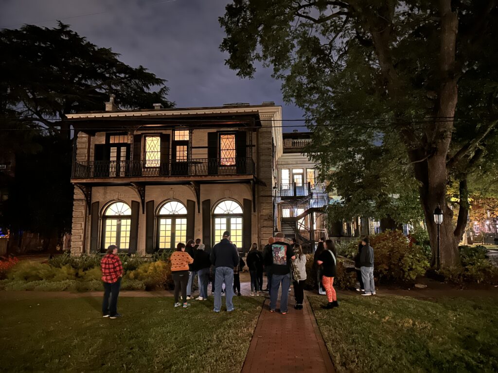 Tour group listening to a guide during a Creepy Tales on Campus tour at Scott House in Richmond, Virginia.